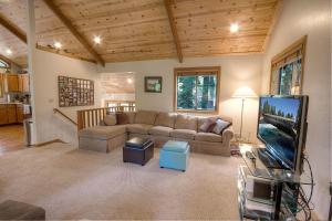uma sala de estar com um sofá e uma televisão de ecrã plano em Sunnyside Up cabin em Tahoe City