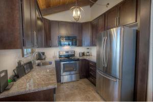 a kitchen with wooden cabinets and a stainless steel refrigerator at Tahoe Olympic condo in Stateline