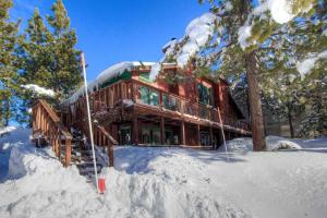 a wooden house in the snow with snow covered trees at Tahoe Olympic condo in Stateline