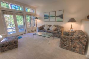 a living room with two couches and a table at Delightful McCloud condo in Incline Village