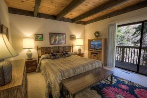 um quarto com uma cama e um tecto de madeira em Forest View Townhouse home em Kings Beach