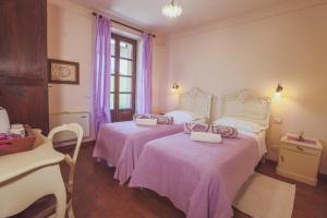 um quarto com 2 camas com lençóis cor-de-rosa e um piano em Agriturismo Tre Stelle em Barbaresco