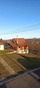 a house on a hill next to a road at Porodicna brvnara Ivanovic in Zlatibor