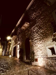 een stenen gebouw met een potplant in een straat 's nachts bij Le Camere dell’Emiro in Castronuovo di Sicilia