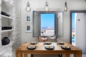 a dining room with a wooden table and a large window at M&D Stories in Pirgos