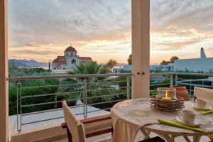 einen Tisch auf einem Balkon mit Blick auf ein Gebäude in der Unterkunft Elegant new maisonette near the sea in Ägina Stadt