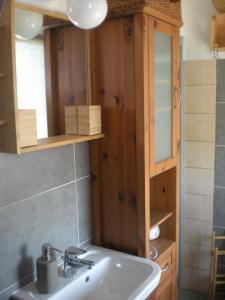 uma casa de banho com um lavatório e um armário de madeira em Müllers WohnRäume em Saarlouis
