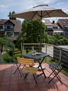 einen Tisch und Stühle mit Sonnenschirm auf einer Terrasse in der Unterkunft Müllers WohnRäume in Saarlouis