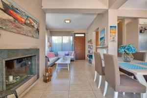 a living room with a fireplace and a dining room at Elegant new maisonette near the sea in Aegina Town