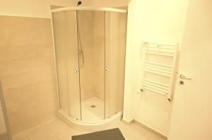 y baño con ducha blanca. en Luana Airport Apartments #4, en Otopeni