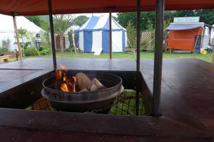 a grill with a pot of fire in a tent at Fred's Yurts at Hay Festival in Hay-on-Wye