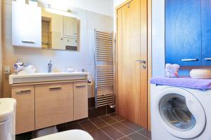 ein Badezimmer mit einer Waschmaschine und einem Waschbecken in der Unterkunft Elegant new maisonette near the sea in Ägina Stadt