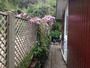 a fence with flowers on it next to a house at Whiteshell Chalets in The Mumbles