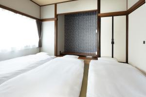 two beds in a room with a window at The minpark in Dazaifu