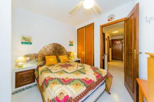 ein Schlafzimmer mit einem Bett mit einer farbenfrohen Tagesdecke in der Unterkunft Alegria ID63 in Torrevieja