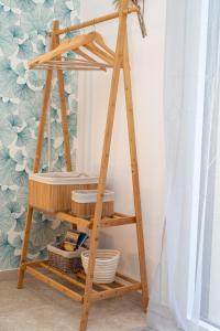 a wooden shelf with baskets on it next to a curtain at Terre et Mer in Favières