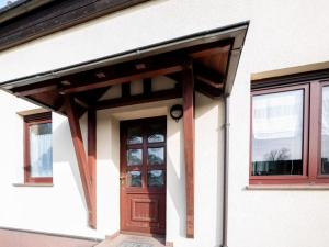 a house with a wooden door and windows at Ferienwohnung Bär in Großräschen