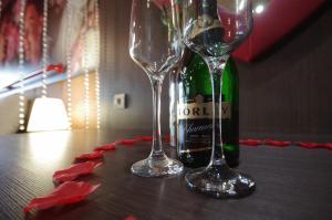 two wine glasses and a bottle of champagne on a table at Hotel Corvin in Gyula