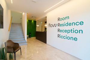 un corridoio con scala e un cartello che indica la capacità di ricezione di Residence Flow-R a Riccione