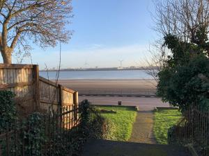a fence with a view of a body of water at Modern 2 bed apartment in Wallasey