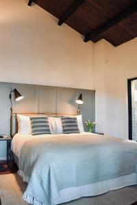 ein Schlafzimmer mit einem großen Bett mit zwei Lampen in der Unterkunft Villa Menaluna - 4-bedroom secluded country house with pool in Rocchetta Palafea