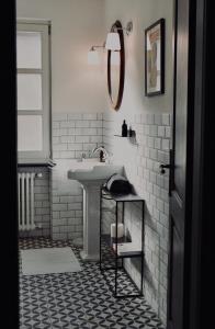 ein Badezimmer mit einem Waschbecken und einer weiß gefliesten Wand in der Unterkunft Villa Menaluna - 4-bedroom secluded country house with pool in Rocchetta Palafea