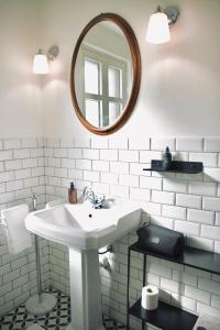 ein weißes Badezimmer mit einem Waschbecken und einem Spiegel in der Unterkunft Villa Menaluna - 4-bedroom secluded country house with pool in Rocchetta Palafea