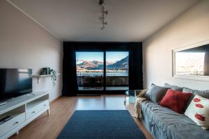 un soggiorno con divano e una grande finestra di Paradise by Quokka 360 - with a 180 view of the Gulf of Lugano a Paradiso
