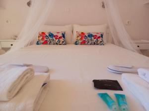 a bedroom with a white bed with towels and pillows at Stamatia's Houses in Agios Georgios