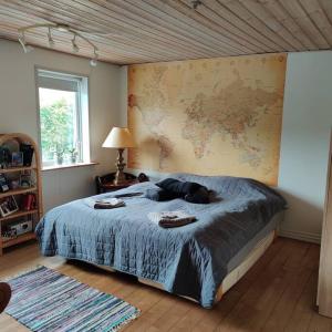 1 dormitorio con 1 cama grande y un mapa en la pared en Vidunderligt hus i landlige omgivelser, en Spottrup