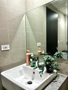 La salle de bains est pourvue d'un lavabo et d'un miroir. dans l'établissement LOVELY AND COZY -Executive 1BR in Uptown Parksuites Tower 1-BGC, à Manille