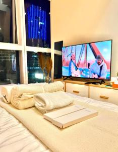 - une chambre avec un lit et une télévision à écran plat dans l'établissement LOVELY AND COZY -Executive 1BR in Uptown Parksuites Tower 1-BGC, à Manille