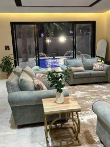 ein Wohnzimmer mit 2 Sofas und einem Tisch in der Unterkunft لورينا شالية in Al Hofuf