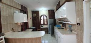 una cucina con mobili bianchi e un lavandino di Nile View Panoramique and Garden West bank a Luxor Altre 39 foto