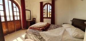 una camera da letto con un letto e una porta di legno di Nile View Panoramique and Garden West bank a Luxor