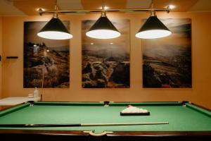 - un billard dans une pièce avec trois lumières dans l'établissement Готель Хутір, à Malyye Khutora