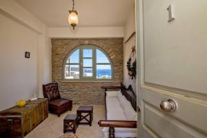 a living room with a couch and a window at m.houses1 in Agios Romanos
