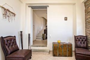 a living room with two leather chairs and a trunk at m.houses1 in Agios Romanos
