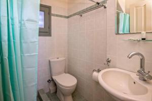 a bathroom with a toilet and a sink and a mirror at m.houses1 in Agios Romanos +44 photos