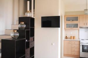 a kitchen with a black shelf with vases on it at m.houses1 in Agios Romanos