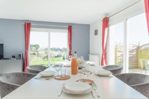 ein Esszimmer mit einem weißen Tisch und Stühlen in der Unterkunft PENN AR ROZ - Grande maison familiale proche mer in Saint-Pabu + 42 Fotos