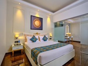 a bedroom with a large white bed and a table at Enrise By Sayaji Rau Indore in Indore