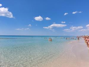 a group of people in the water on a beach at Villa Roberta Spiaggiabianca Deluxe - A 20 metri dal mare in San Pietro in Bevagna
