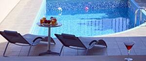a table and chairs next to a swimming pool at Arion Villa in Xirokámbion
