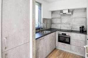 a kitchen with stainless steel cabinets and a sink at Tof wellness huis, alles nieuw, gelegen bij meer. in Ewijk