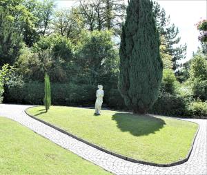a statue in a garden next to a tree at Haus Bethania Ferienwohnung piccolo in Bad Kissingen