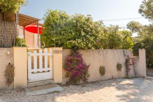 une clôture avec un portail en face d'une maison dans l'établissement La Bastide, villa en duplex idéalement située à quelques pas de la mer, à Hyères