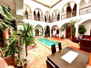 une cour avec une piscine dans un bâtiment dans l'établissement Riad Mandalay, à Marrakech