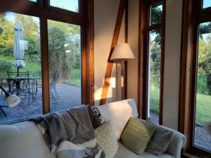 a living room with a white couch and windows at Kenmare Eco Lodge in Kenmare