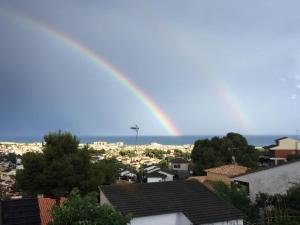a rainbow in the sky over a city at Precioso apartamento con vista al mar in Calafell